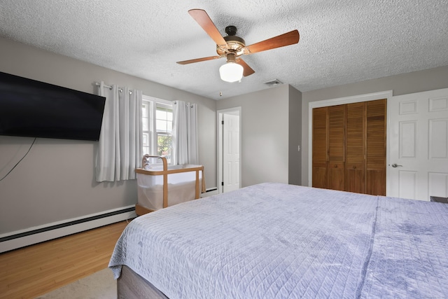 32 Butternut Ridge Rd, Waterbury, CT 06706 - bedroom featuring wood finished floors, a closet, a textured ceiling, a baseboard radiator, and ceiling fan