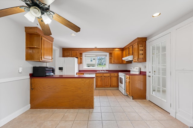 630 French St, Watertown, CT 06779 - kitchen with white appliances, open shelves, under cabinet range hood, brown cabinets, and a peninsula