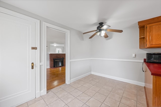630 French St, Watertown, CT 06779 - unfurnished dining area with ceiling fan, a fireplace, and light tile patterned flooring