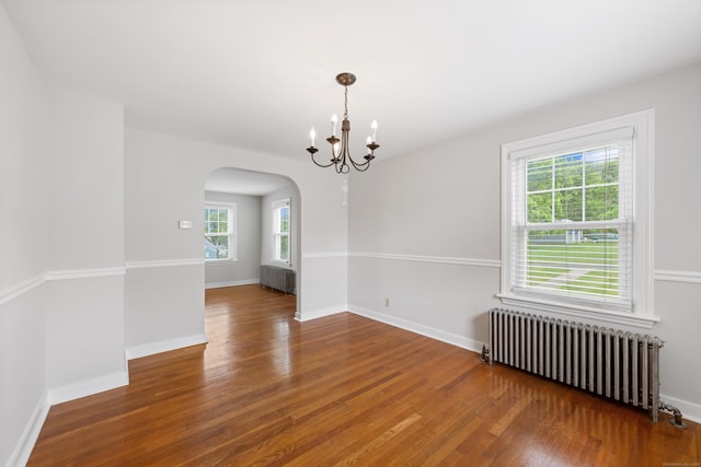 630 French St, Watertown, CT 06779 - spare room featuring radiator heating unit, arched walkways, wood finished floors, and a chandelier