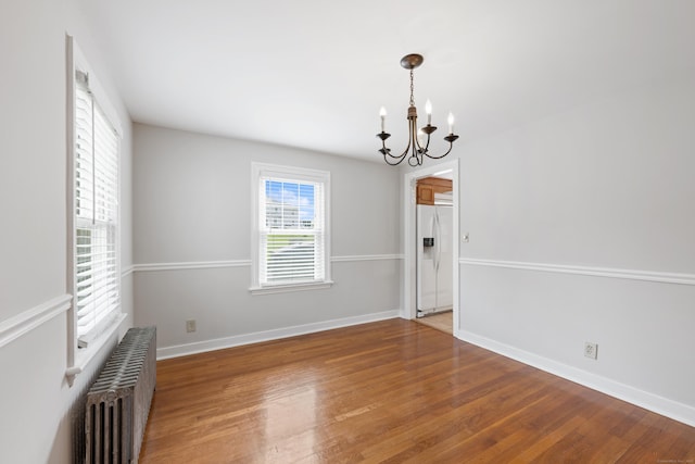 630 French St, Watertown, CT 06779 - empty room with a chandelier, radiator heating unit, and wood finished floors