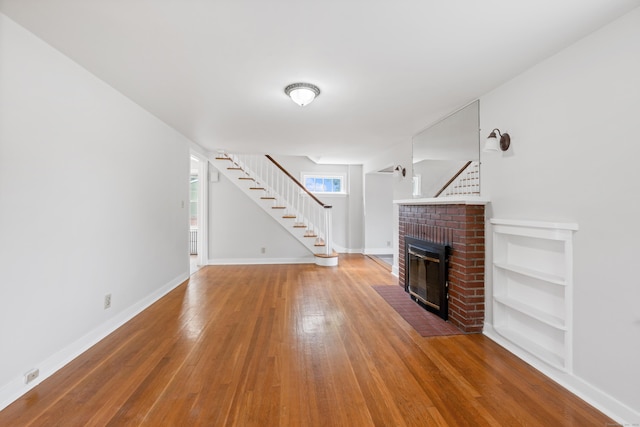 630 French St, Watertown, CT 06779 - unfurnished living room with a fireplace, stairway, and wood finished floors