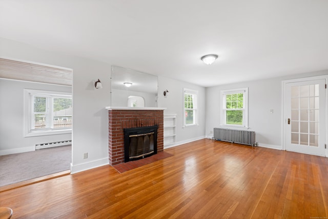 630 French St, Watertown, CT 06779 - unfurnished living room featuring radiator, wood finished floors, baseboard heating, and a fireplace