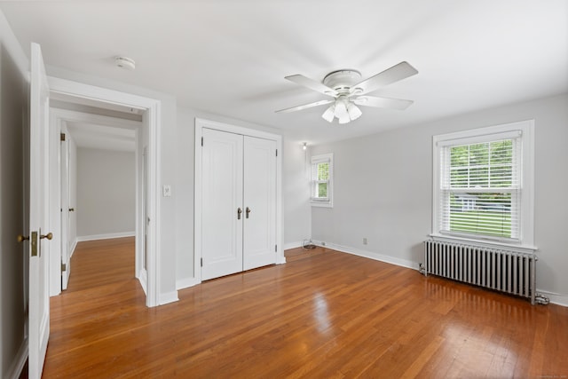 630 French St, Watertown, CT 06779 - unfurnished bedroom with radiator heating unit, wood finished floors, a closet, and a ceiling fan