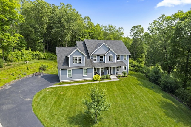 257 Ichabod Rd, Southbury, CT 06488 - colonial home featuring asphalt driveway, covered porch, and a front lawn