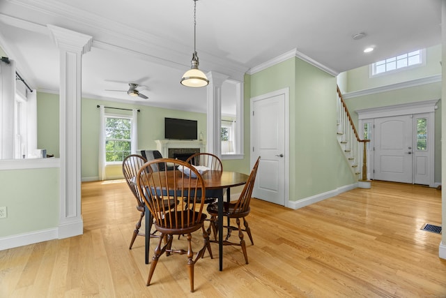 257 Ichabod Rd, Southbury, CT 06488 - dining area featuring stairs, crown molding, a fireplace, ornate columns, and light wood finished floors