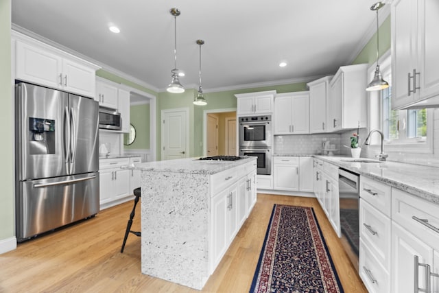257 Ichabod Rd, Southbury, CT 06488 - kitchen featuring appliances with stainless steel finishes, a kitchen island, white cabinets, crown molding, and recessed lighting
