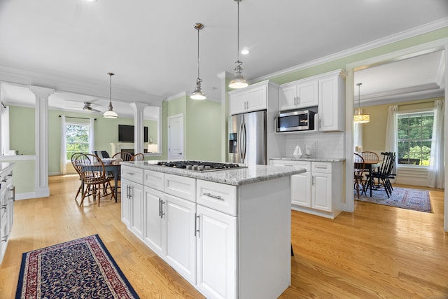 257 Ichabod Rd, Southbury, CT 06488 - kitchen featuring decorative columns, stainless steel appliances, a center island, light wood-style flooring, and crown molding