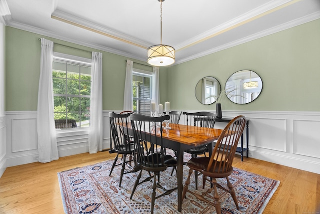 257 Ichabod Rd, Southbury, CT 06488 - dining area with crown molding, a wainscoted wall, a raised ceiling, light wood-type flooring, and a decorative wall