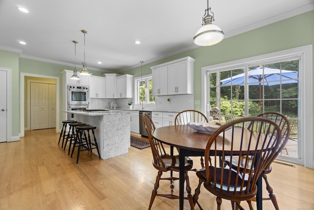 257 Ichabod Rd, Southbury, CT 06488 - dining room featuring light wood-type flooring, crown molding, and recessed lighting