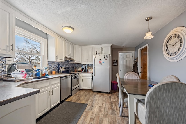 52 Irving St Apt 4, Bristol, CT 06010 - kitchen featuring stainless steel appliances, a textured ceiling, light wood finished floors, decorative backsplash, and white cabinetry