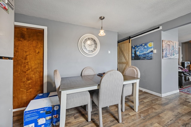 52 Irving St Apt 4, Bristol, CT 06010 - dining area with a barn door, wood finished floors, and a textured ceiling