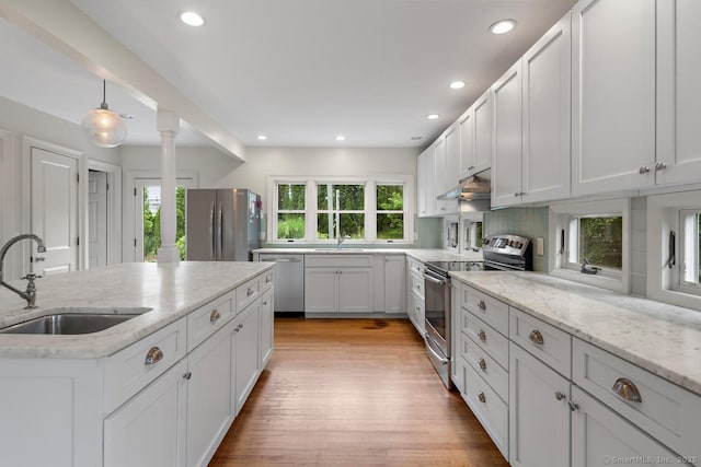 19 Sherwood Dr, Westport, CT 06880 - kitchen featuring appliances with stainless steel finishes, light wood finished floors, white cabinetry, recessed lighting, and light stone countertops