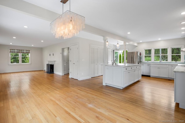 19 Sherwood Dr, Westport, CT 06880 - kitchen with appliances with stainless steel finishes, a chandelier, an island with sink, light countertops, and light wood-type flooring