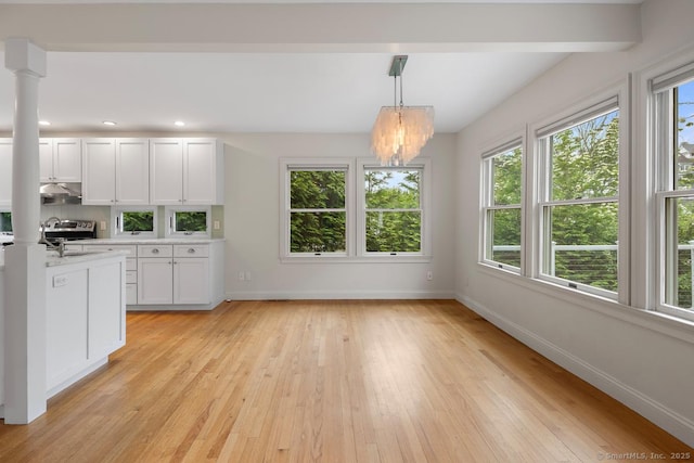 19 Sherwood Dr, Westport, CT 06880 - kitchen with under cabinet range hood, light countertops, light wood-type flooring, a chandelier, and white cabinets