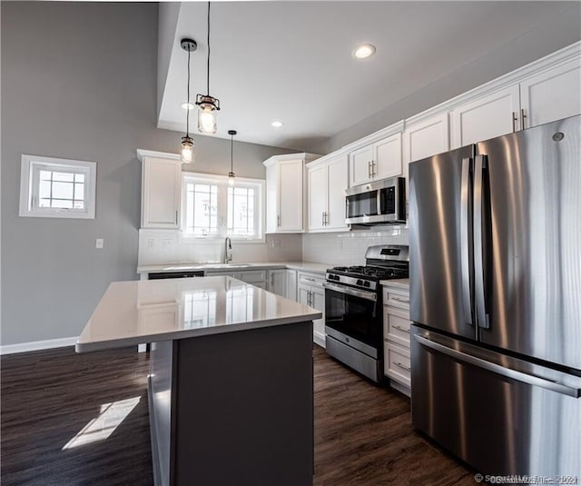 4 Lombard Cir Unit 4, North Haven, CT 06473 - kitchen with appliances with stainless steel finishes, a center island, dark wood-type flooring, tasteful backsplash, and recessed lighting