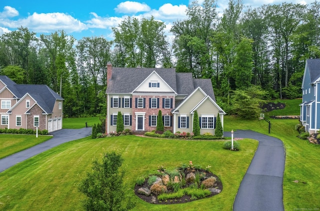 35 Bridgehampton Xing, Farmington, CT 06085 - view of front of home with asphalt driveway, a garage, a chimney, a front yard, and brick siding