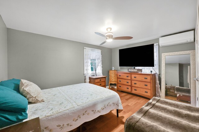 1117 N Grand St, Suffield, CT 06093 - bedroom with a wall unit AC, light wood-style flooring, and ceiling fan