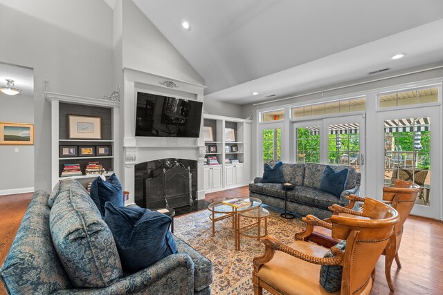 45 Shaker Ct, Guilford, CT 06437 - living room featuring wood finished floors, high vaulted ceiling, a high end fireplace, recessed lighting, and built in shelves