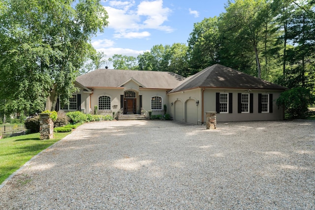 45 Shaker Ct, Guilford, CT 06437 - view of front of house featuring stucco siding, a garage, and driveway