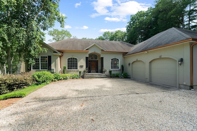 45 Shaker Ct, Guilford, CT 06437 - ranch-style house with driveway, stucco siding, an attached garage, and a shingled roof