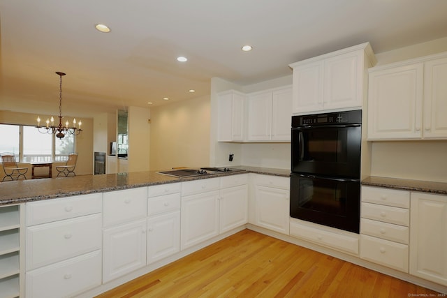 73 Harbour View Pl Unit 73, Stratford, CT 06615 - kitchen with stainless steel cooktop, dark stone countertops, light wood-style floors, a peninsula, and white cabinetry
