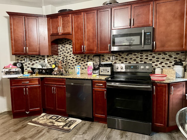 14 Natalie St, Hartford, CT 06106 - kitchen featuring stainless steel appliances, dark brown cabinets, light wood finished floors, and light stone countertops