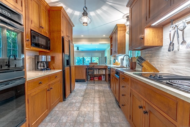 55 Main St, East Haddam, CT 06423 - kitchen with brown cabinetry, light countertops, black appliances, tasteful backsplash, and decorative light fixtures