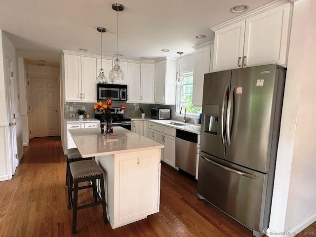 8 Breezy Knoll Ave, Wolcott, CT 06716 - kitchen featuring appliances with stainless steel finishes, dark wood-type flooring, white cabinetry, backsplash, and hanging light fixtures