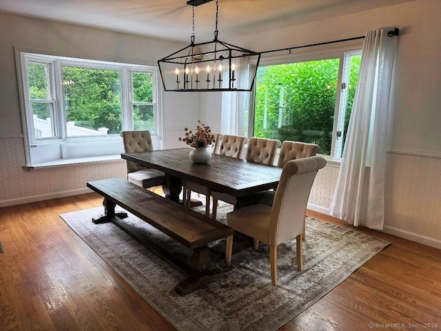 8 Breezy Knoll Ave, Wolcott, CT 06716 - dining room featuring a chandelier, plenty of natural light, wainscoting, wood finished floors, and wood walls