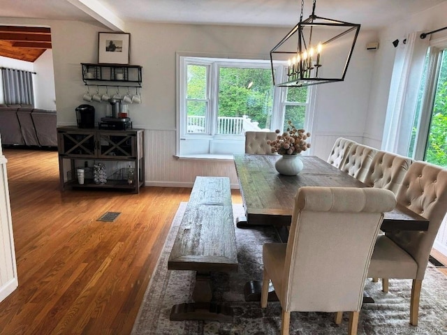 8 Breezy Knoll Ave, Wolcott, CT 06716 - dining area featuring healthy amount of natural light, wood finished floors, a wainscoted wall, and a chandelier
