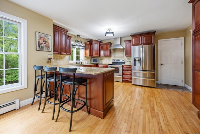 5 Goldfinch Ter, East Lyme, CT 06333 - kitchen with appliances with stainless steel finishes, wall chimney range hood, reddish brown cabinets, a peninsula, and tasteful backsplash