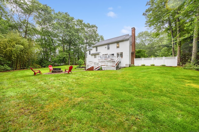 5 Goldfinch Ter, East Lyme, CT 06333 - back of house featuring an outdoor fire pit, a deck, a chimney, and view of wooded area
