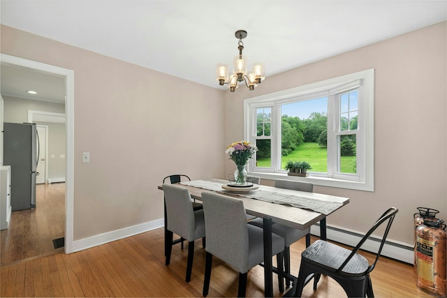1027 Monroe Tpke, Monroe, CT 06468 - dining space featuring a baseboard heating unit, a chandelier, and light wood-style flooring