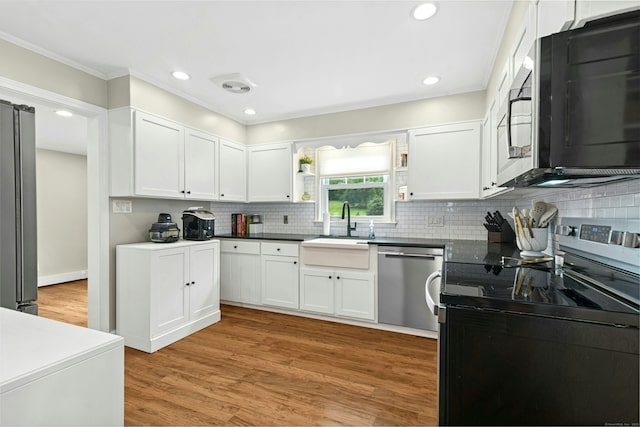 1027 Monroe Tpke, Monroe, CT 06468 - kitchen with appliances with stainless steel finishes, ornamental molding, white cabinetry, backsplash, and light wood-type flooring
