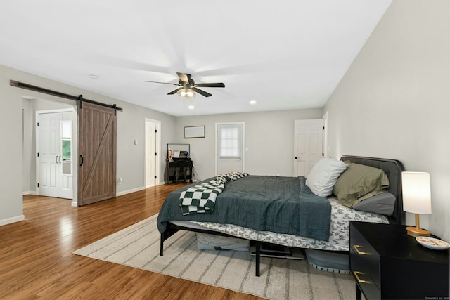 1027 Monroe Tpke, Monroe, CT 06468 - bedroom featuring a barn door, wood finished floors, a ceiling fan, and recessed lighting
