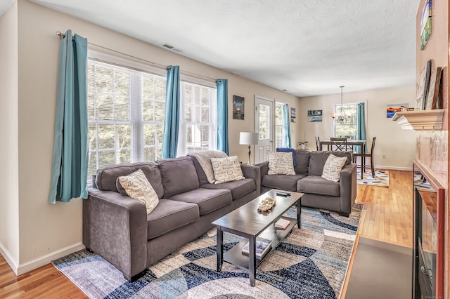 663 W Ave Unit A24, Milford, CT 06461 - living area featuring light wood-type flooring, a chandelier, and a textured ceiling