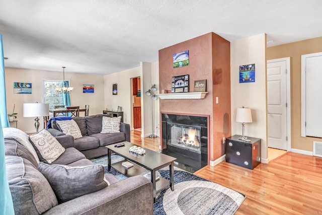 663 W Ave Unit A24, Milford, CT 06461 - living room with wood finished floors, a chandelier, and a large fireplace