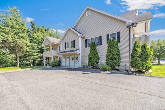 663 W Ave Unit A24, Milford, CT 06461 - view of home's exterior featuring a balcony, a shingled roof, and a garage