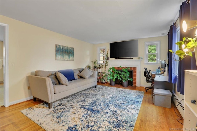 118 W Hartford Rd, Newington, CT 06111 - living room featuring a baseboard radiator, light wood-type flooring, and a fireplace