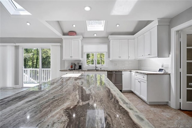 26 Ruscoe Rd, Wilton, CT 06897 - kitchen with a skylight, white cabinets, decorative backsplash, and recessed lighting