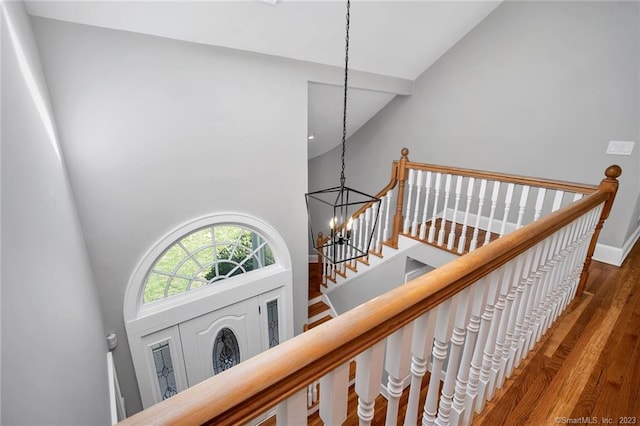 26 Ruscoe Rd, Wilton, CT 06897 - stairway with high vaulted ceiling, a chandelier, and wood finished floors