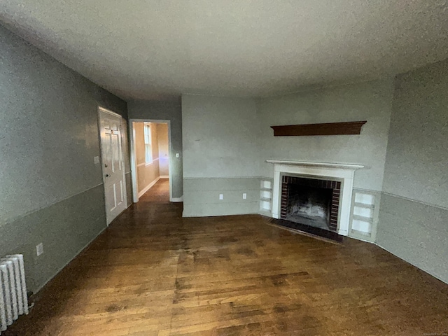 58 Eggleston St, Torrington, CT 06790 - unfurnished living room with radiator heating unit, a fireplace, and wood finished floors
