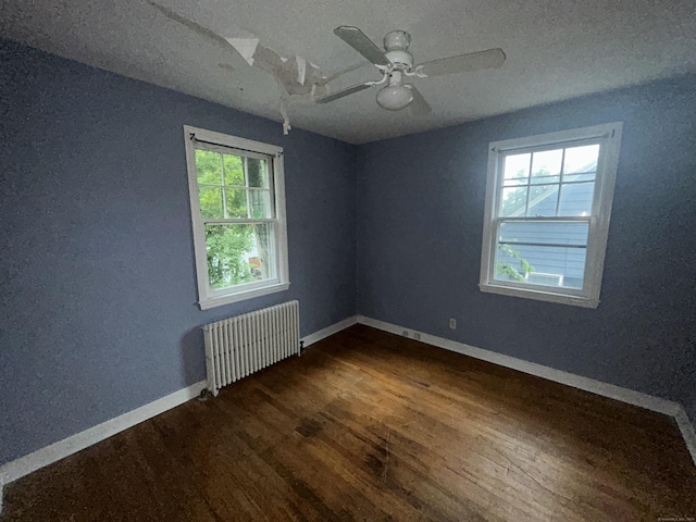 58 Eggleston St, Torrington, CT 06790 - spare room featuring radiator, plenty of natural light, dark wood-type flooring, a ceiling fan, and a textured ceiling