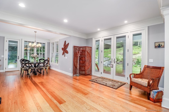 dining space with french doors, a chandelier, ornamental molding, light wood finished floors, and recessed lighting