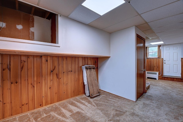47 Hoffman Rd, Manchester, CT 06042 - basement featuring radiator heating unit, carpet floors, a paneled ceiling, and wood walls