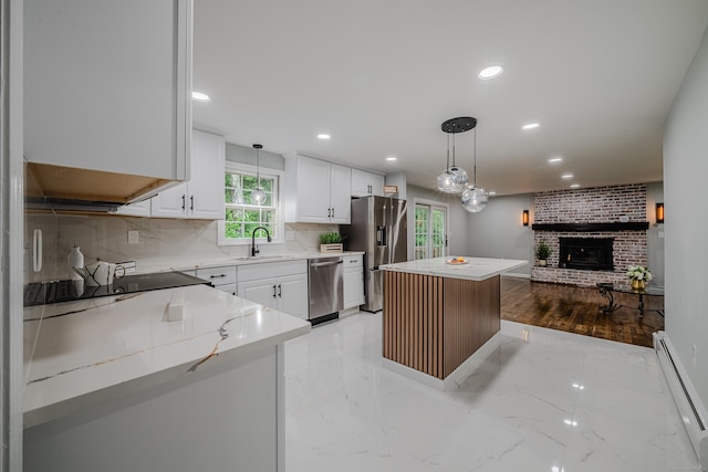 34 Roberts Rd, Marlborough, CT 06447 - kitchen featuring stainless steel appliances, a baseboard heating unit, a brick fireplace, a center island, and decorative backsplash