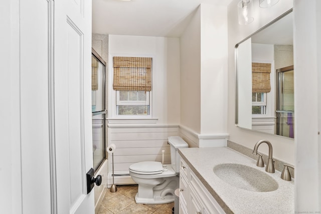 112 Greenbrier Rd, Trumbull, CT 06611 - bathroom with vanity, baseboard heating, wainscoting, tile patterned flooring, and enclosed tub / shower combo