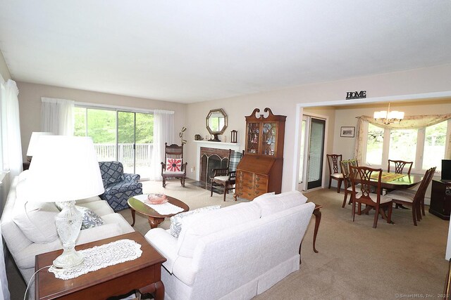 204 W Hill Rd, New Hartford, CT 06057 - living room featuring a chandelier, light carpet, and a brick fireplace