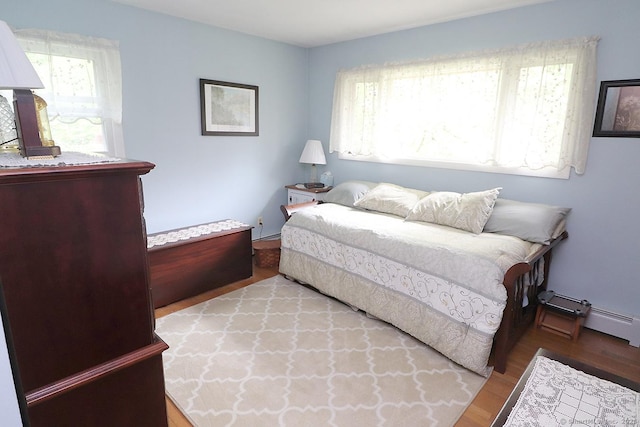 204 W Hill Rd, New Hartford, CT 06057 - bedroom featuring multiple windows, wood finished floors, and a baseboard heating unit